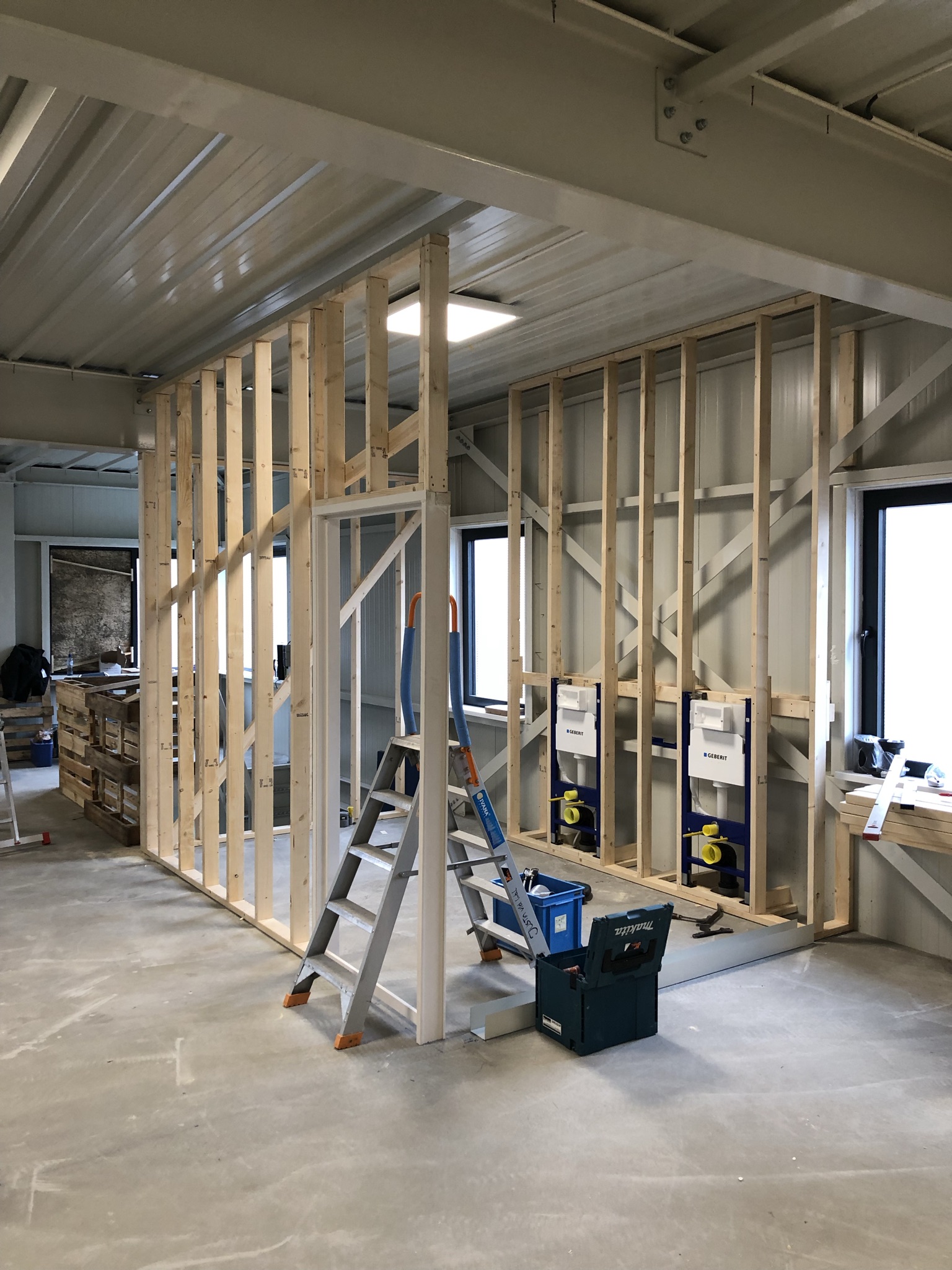 Nieuwe wanden in opbouw met houten stijlen en inbouwreservoirs voor toiletten